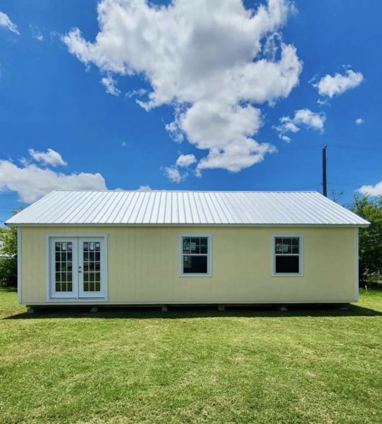 20 by 36 cream cabin shell with a white metal roof